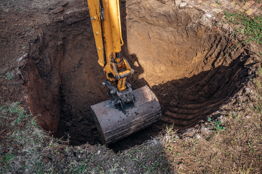 Excavator digging soil during remediation works